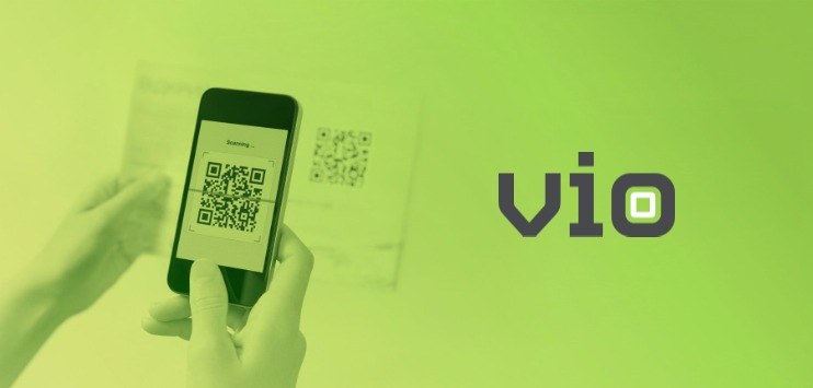Imagem ilustrativa com uma mão segurando um celular, e com a outra, um documento impresso. Na tela do celular, há um QR Code, lido a partir do papel. À direita da imagem do celular, há a logomarca do Vio, marca essa que, segundo os idealizadores, é “limpa” e de fácil fixação, características que também ajudarão no reposicionamento do produto no mercado Imagem ilustrativa com uma mão segurando um celular, e com a outra, um documento impresso. Na tela do celular, há um QR Code, lido a partir do papel. À direita da imagem do celular, há a logomarca do Vio, marca essa que, segundo os idealizadores, é “limpa” e de fácil fixação, características que também ajudarão no reposicionamento do produto no mercado