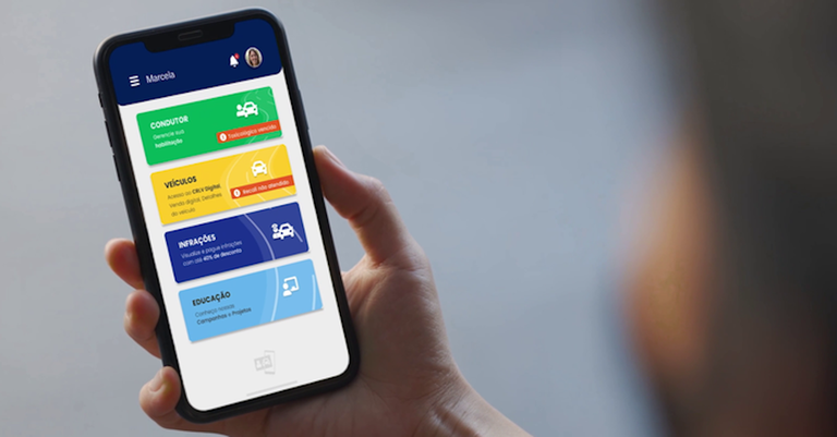 Detalhe de uma mão segurando um celular cuja tela exibe o aplicativo da Carteira Digital de Trânsito (CDT)